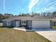 Charming single-story home featuring a two-car garage, well-maintained lawn, and inviting front entrance at 201 Locust Rd, Ocala, FL 34472