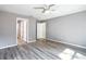 Main bedroom with vinyl floors, ceiling fan, and doorway leading to the ensuite bathroom at 201 Locust Rd, Ocala, FL 34472