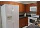 Kitchen with wood cabinets, white appliances, and granite countertop at 21465 Sw Honeysuckle St, Dunnellon, FL 34431