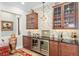 Stylish bar area with wine refrigerators, glass cabinets, and a unique geometric backsplash design at 3690 Nw 56Th Ave, Ocala, FL 34482