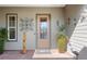 Inviting front door with a glass panel and decorative art, flanked by potted plants and sconce lighting at 3690 Nw 56Th Ave, Ocala, FL 34482