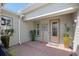 View of the tiled front porch with tasteful decor and a neutral-colored front door at 3690 Nw 56Th Ave, Ocala, FL 34482