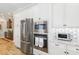 Modern kitchen features stainless steel appliances, white cabinets, and contrasting backsplash at 3690 Nw 56Th Ave, Ocala, FL 34482