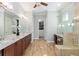 Spacious main bathroom featuring dual sinks, granite countertops, wood cabinetry, and glass enclosed shower at 3690 Nw 56Th Ave, Ocala, FL 34482