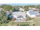 Aerial view of home featuring screened lanai, stone patio, and landscaped yard at 3923 Manor Oaks Ct, Leesburg, FL 34748
