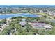 Beautiful aerial view of the community featuring a lake, pool, clubhouse, and tennis courts at 3923 Manor Oaks Ct, Leesburg, FL 34748