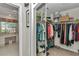 Walk-in closet with organized storage solutions and next to the ensuite bathroom at 3923 Manor Oaks Ct, Leesburg, FL 34748