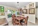 Charming dining room features a wood table, six chairs, and large window at 3923 Manor Oaks Ct, Leesburg, FL 34748