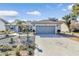 House exterior featuring a gray garage door and well-maintained landscaping at 3923 Manor Oaks Ct, Leesburg, FL 34748