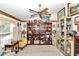 Bright library features a large bookcase, comfortable chair and natural light at 3923 Manor Oaks Ct, Leesburg, FL 34748