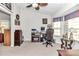 Well-lit home office with a vaulted ceiling, computer setup, and comfortable seating at 3923 Manor Oaks Ct, Leesburg, FL 34748