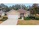 Single-story home with attached garage, landscaping, and a paved driveway at 5409 Sw 42Nd Pl, Ocala, FL 34474