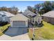 One-story house with a two-car garage, nicely landscaped yard, and American flag at 6760 Sw 112Th St, Ocala, FL 34476