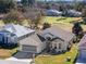 House with a two car garage, manicured lawn, and American flag at 6760 Sw 112Th St, Ocala, FL 34476