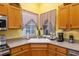 Corner sink in kitchen with wood cabinets and granite countertops at 6760 Sw 112Th St, Ocala, FL 34476