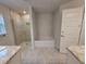 A spacious bathroom offers a glass enclosed shower, soaking tub, and light granite countertops at 6915 Sw 152Nd St, Ocala, FL 34473