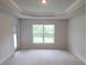 A bedroom showcases a door to the outside and a view through a light-filled window at 6915 Sw 152Nd St, Ocala, FL 34473