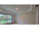 A bedroom offers a stylish tray ceiling design and a light-filled view from the window at 6915 Sw 152Nd St, Ocala, FL 34473