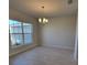 Well-lit dining room featuring tile floors, a chandelier, and a large window at 6915 Sw 152Nd St, Ocala, FL 34473