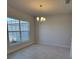 Well-lit dining room featuring tile floors, a chandelier, and a large window at 6915 Sw 152Nd St, Ocala, FL 34473