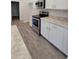 Well-lit kitchen featuring stainless steel appliances, white cabinets, and granite countertops at 6915 Sw 152Nd St, Ocala, FL 34473