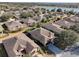 Aerial view showcasing a residential neighborhood with tree-lined streets and a picturesque lake nearby at 7387 Sw 99Th Ct, Ocala, FL 34481