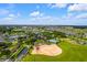 Expansive aerial view showcasing the community, baseball field, sports courts, green spaces, and surrounding residential area at 7387 Sw 99Th Ct, Ocala, FL 34481