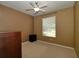 Bedroom featuring a ceiling fan, neutral colored walls, carpet flooring and a window for plenty of light at 7387 Sw 99Th Ct, Ocala, FL 34481