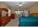 Cozy bedroom features a ceiling fan, a dresser, and a window at 7387 Sw 99Th Ct, Ocala, FL 34481