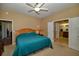 Cozy bedroom features a ceiling fan, and easy access to the ensuite bathroom at 7387 Sw 99Th Ct, Ocala, FL 34481