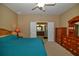 Cozy bedroom features a ceiling fan, a dresser, and easy access to the ensuite bathroom at 7387 Sw 99Th Ct, Ocala, FL 34481