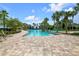 Large community pool with ample lounge seating, surrounded by lush landscaping and palm trees at 7387 Sw 99Th Ct, Ocala, FL 34481