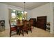 Formal dining room with large window, antique dining set and tiled floor at 7387 Sw 99Th Ct, Ocala, FL 34481