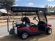 Maroon golf cart showing back seat, canopy and golf bag carrier, parked along a road at 7387 Sw 99Th Ct, Ocala, FL 34481