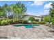 Outdoor hot tub surrounded by lush greenery and a beautiful stone patio at 7387 Sw 99Th Ct, Ocala, FL 34481