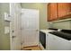 Laundry room featuring a modern washer and dryer set and wood cabinets above at 7387 Sw 99Th Ct, Ocala, FL 34481