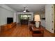 Living room with hardwood floors, leather furniture, ceiling fan, and access to the patio at 7387 Sw 99Th Ct, Ocala, FL 34481