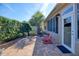 Charming outdoor patio with brick pavers, inviting Adirondack chairs, and manicured landscaping at 7387 Sw 99Th Ct, Ocala, FL 34481