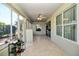 Bright sunroom featuring tile floors, a ceiling fan, multiple windows, and access to the backyard at 7387 Sw 99Th Ct, Ocala, FL 34481