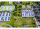 Aerial view of tennis and pickleball courts with colorful surfaces and well-maintained landscaping in a vibrant community at 7387 Sw 99Th Ct, Ocala, FL 34481