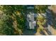 Aerial view of a home with a spacious roof, a driveway, and mature trees surrounding the property at 7556 Sw 112Th Ln, Ocala, FL 34476