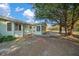 Home's back exterior showcasing a screened patio and mature trees at 7556 Sw 112Th Ln, Ocala, FL 34476