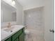 Clean bathroom with green vanity, marble shower, and wood-look floors at 7556 Sw 112Th Ln, Ocala, FL 34476