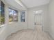 Sunlit bedroom with wood-look floors and three large windows showing the exterior at 7556 Sw 112Th Ln, Ocala, FL 34476
