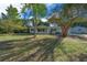 Light green house with a screened porch and attached garage, set back from the road with a spacious yard at 7556 Sw 112Th Ln, Ocala, FL 34476