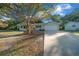 Light green house with a long driveway and trees at 7556 Sw 112Th Ln, Ocala, FL 34476