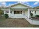 Light green house with covered porch and landscaping at 7556 Sw 112Th Ln, Ocala, FL 34476