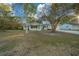 Light green house with a porch and trees in front at 7556 Sw 112Th Ln, Ocala, FL 34476