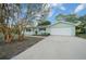 Charming home with a well-maintained lawn, mature trees, and a driveway leading to the garage at 7556 Sw 112Th Ln, Ocala, FL 34476