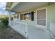 Inviting front porch with white railing and screen door at 7556 Sw 112Th Ln, Ocala, FL 34476